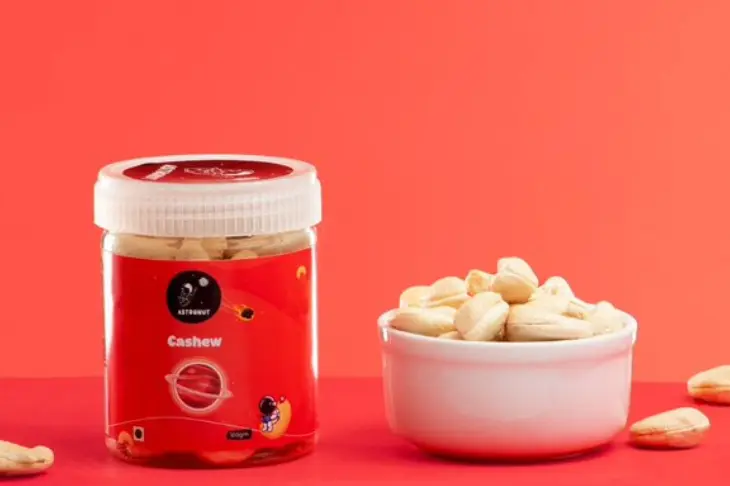 A jar and bowl filled with cashews, showcasing the nut's rich color and texture clicked by a amazing photographer