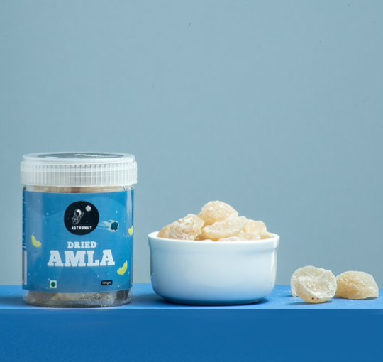 A Picture of a jar of sugar-coated dried amla with a pale and dark blue background indicates E-commerce style of photography
