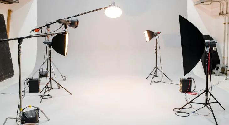 A photography studio setup with multiple lights and softboxes arranged is ready for a photoshoot.