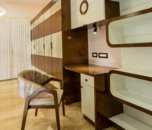 A furnished room featuring a desk & chair, providing a comfortable & functional workspace a well captured photography.
