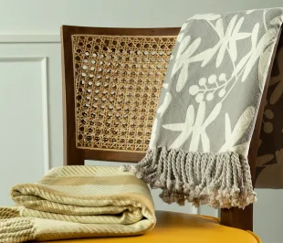 A chair adorned with a cozy blanket and a neatly folded towel, inviting relaxation pictured in a perfect photography.