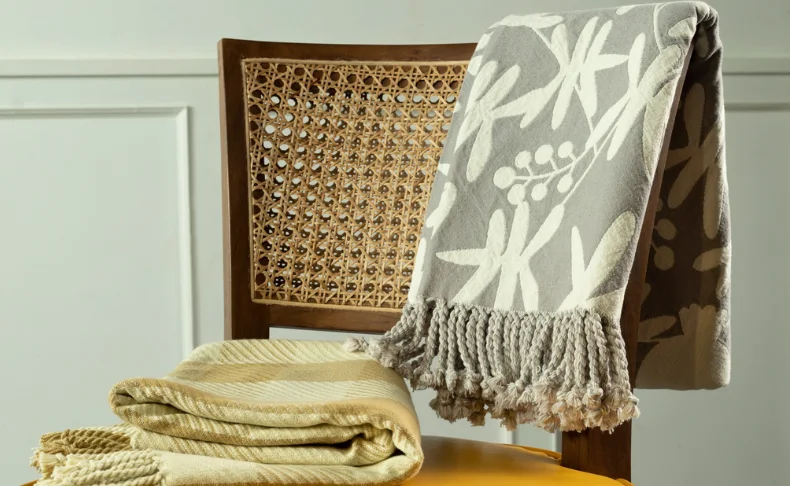 A chair adorned with a cozy blanket and a neatly folded towel, inviting relaxation pictured in a perfect photography.