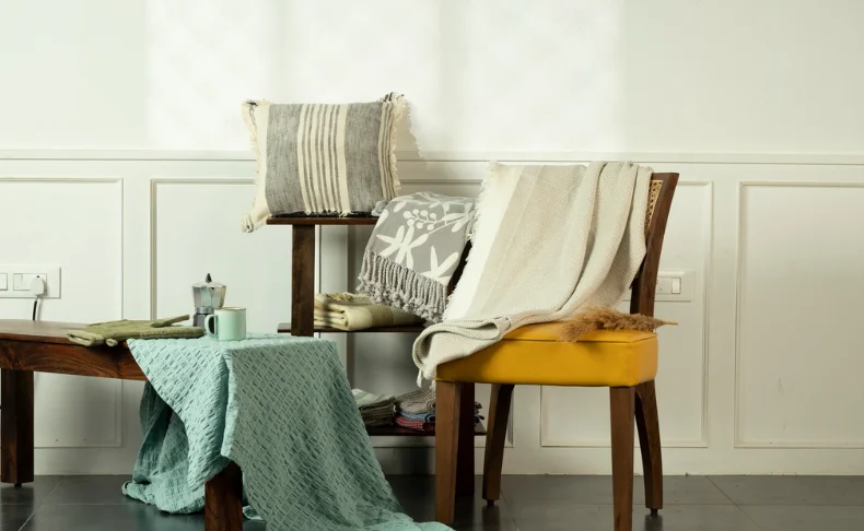 A chair adorned with a cozy blanket and a neatly folded towel, inviting relaxation pictured in a perfect photography.